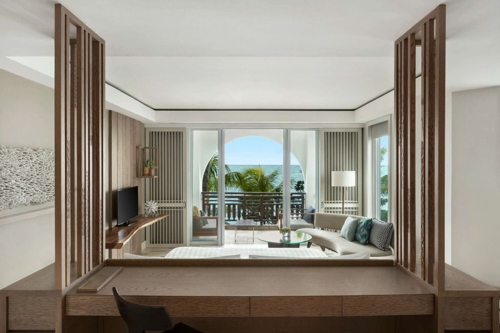 Panoramafenster im Zimmer mit Blick auf Palmen und Meer