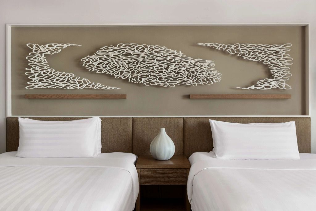 Zwei Betten in einem modernen Hotelzimmer mit stilvoller Wandkunst