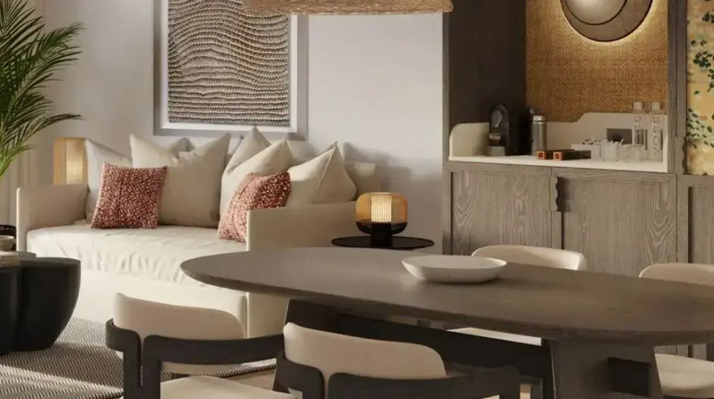 Wohnbereich mit Esstisch, Sofa und Kunstwerk an der Wand in einer modernen Suite