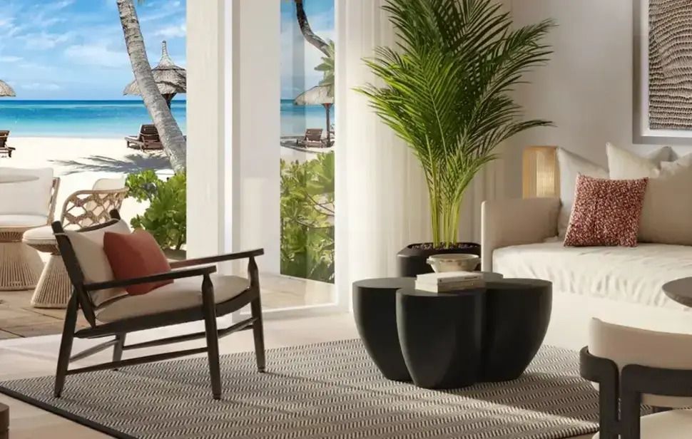 Heller Raum mit Blick auf tropischen Strand und Palmen durch große Fenster