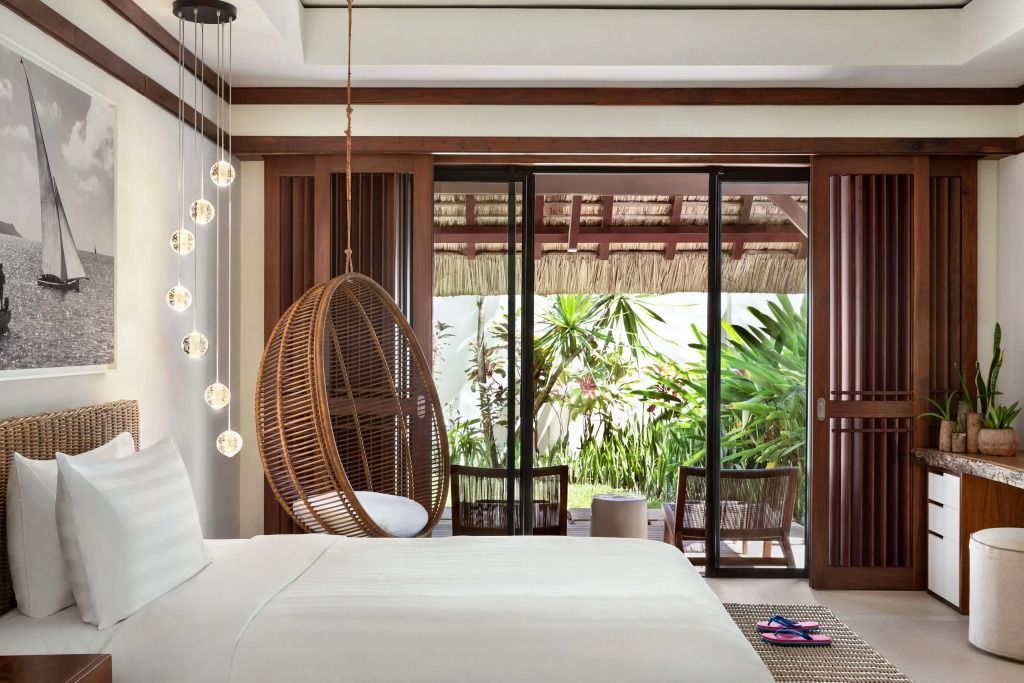 Luftige Suite mit Hängekorb im Schlafzimmer und Blick auf tropischen Garten