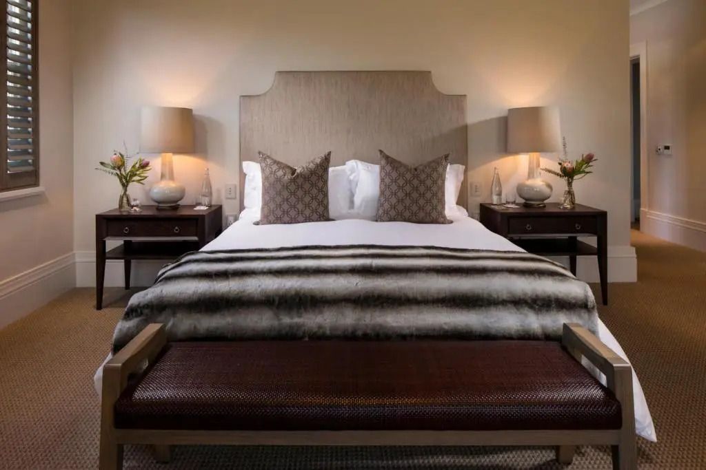 Elegantes Doppelbett mit gestreiftem Wurf und stilvollen Nachttischen.