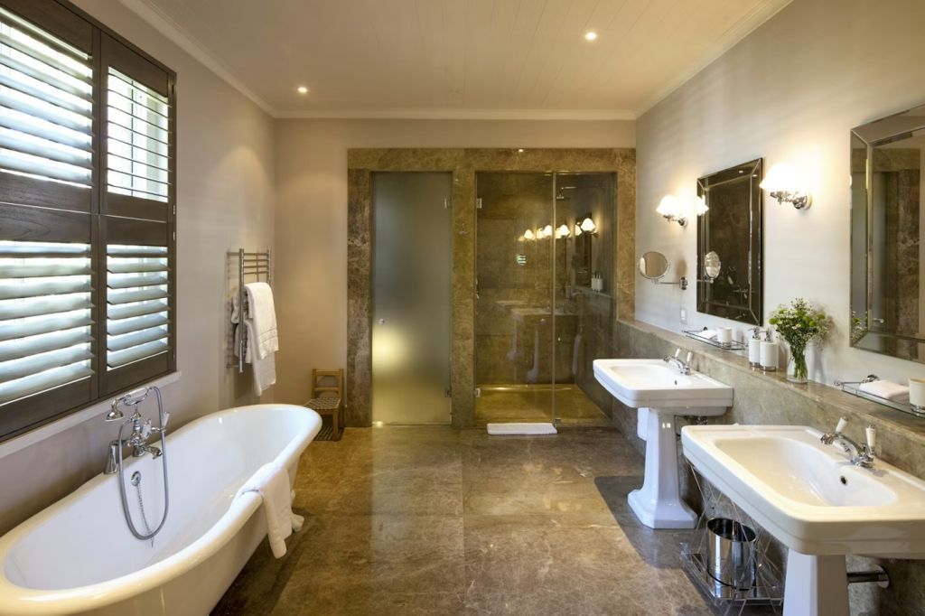 Luxuriöses Badezimmer mit freistehender Badewanne und geräumiger Dusche in der Suite