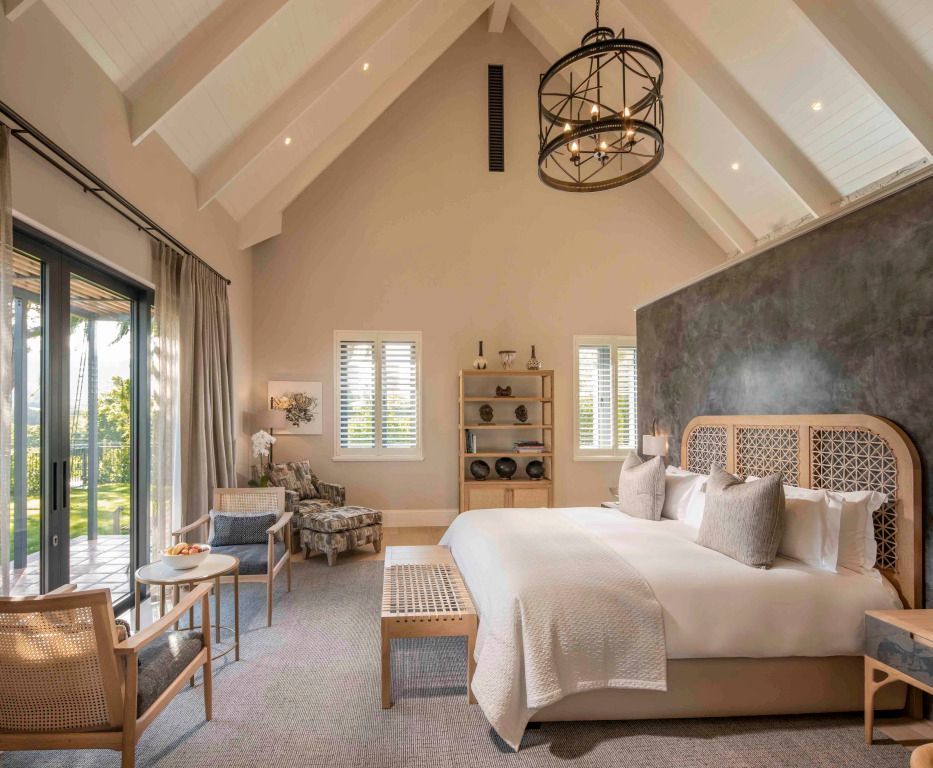 Elegantes Schlafzimmer in der Fynbosch Hütte mit einem luxuriösen Doppelbett und hoher Decke.