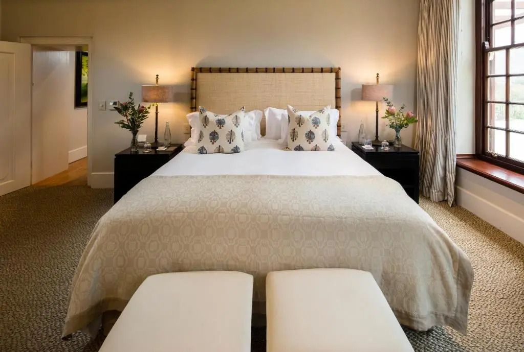 Doppelbett im klassischen Hotelzimmer mit eleganter Bettwäsche und Nachttischen