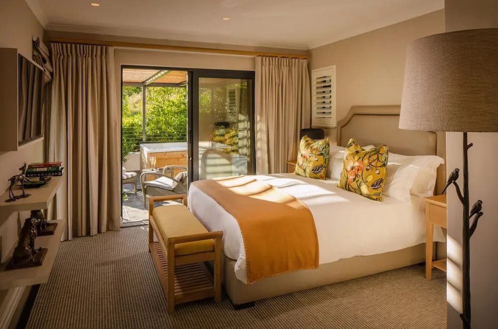 Gemütliches Zimmer mit Doppelbett und Blick auf die Terrasse im Leeu Estate.