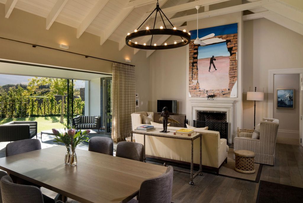 Hochwertig gestaltetes Wohnzimmer mit Kamin, Kunstwerken und Terrasse im Leeu Estate.