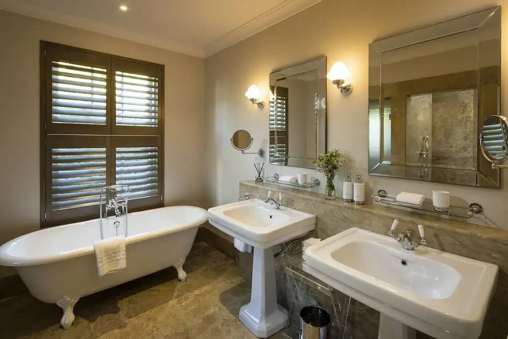 Elegantes Badezimmer mit freistehender Badewanne und Doppelwaschbecken im Leeu Estate.