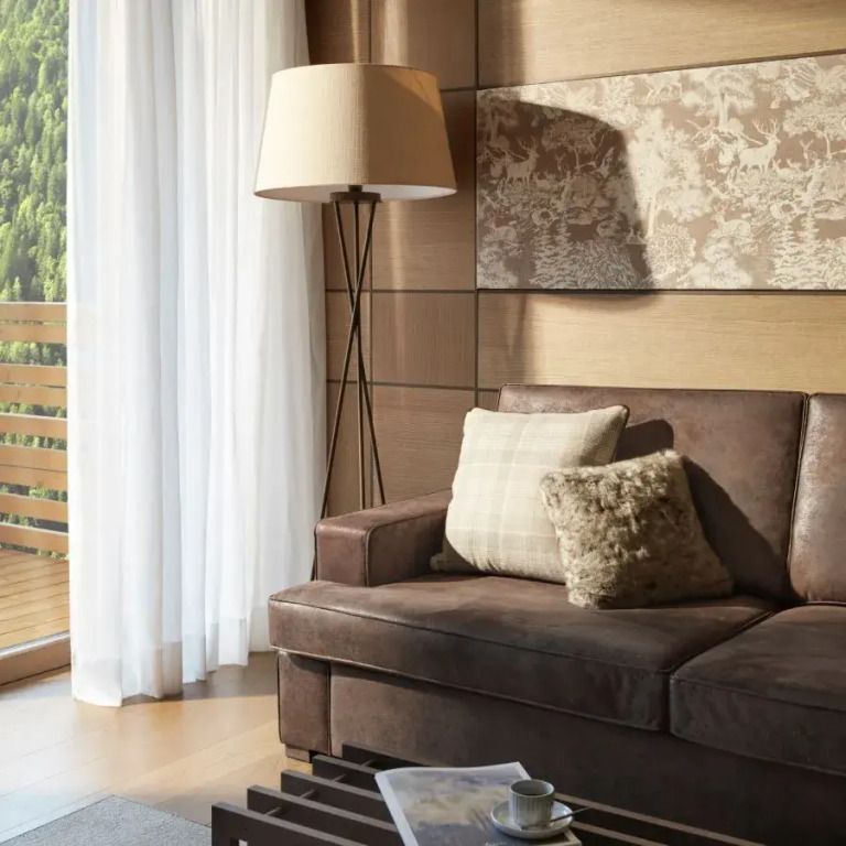 Gemütliche Sitzecke mit Sofa und Lampe in einer Deluxe Junior-Suite