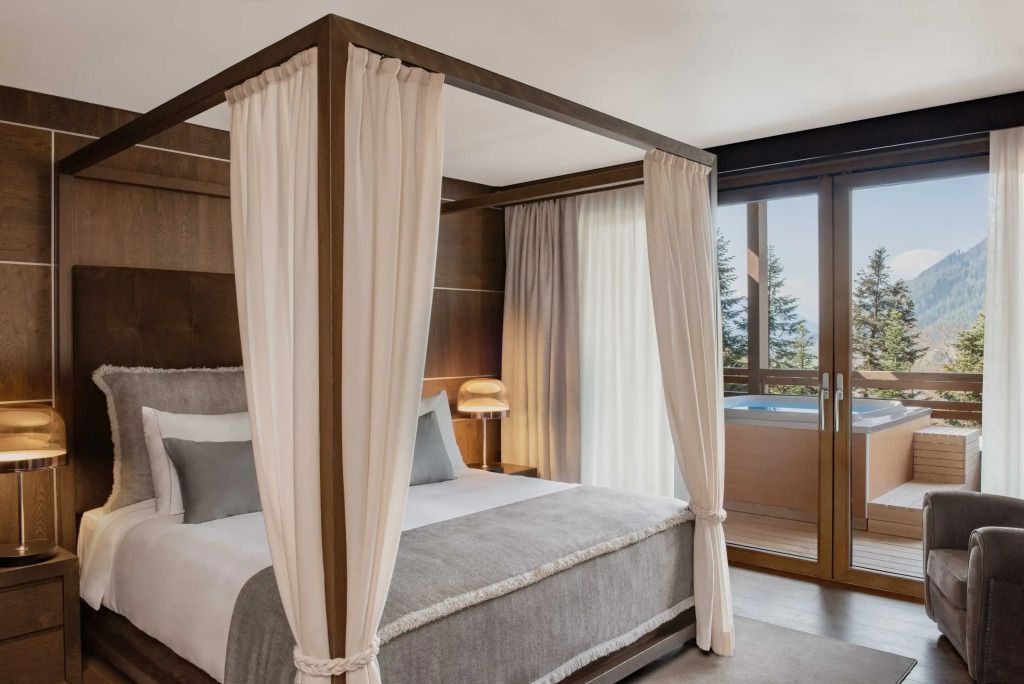Elegantes Schlafzimmer mit Himmelbett und großen Fenstern im Lefay Resort Dolomiti