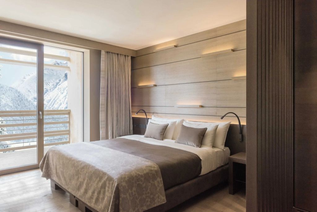 Luxuriöses Schlafzimmer mit großen Fenstern und sanfter Beleuchtung