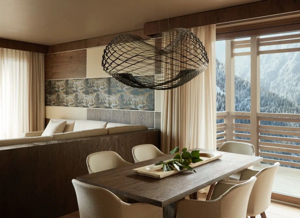 Essbereich mit großem Holztisch, eleganten Stühlen und Bergblick