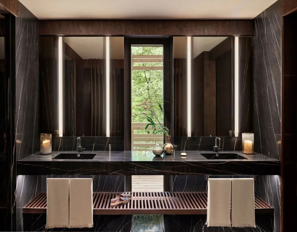 Luxuriöses Badezimmer mit dunklem Marmor und zwei Waschbecken