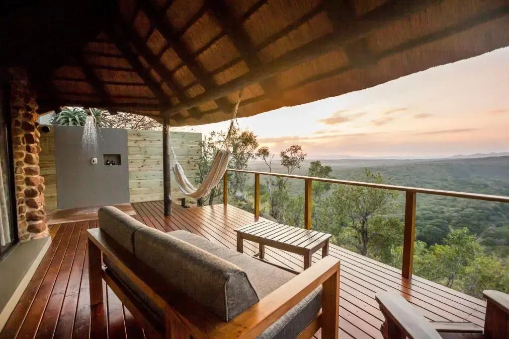 Geräumige Terrasse mit Sofa und Hängematte mit Blick auf die Savanne