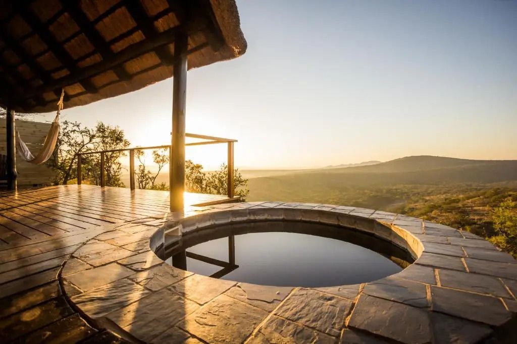 Privater Pool mit Panoramablick über die Landschaft bei Sonnenuntergang