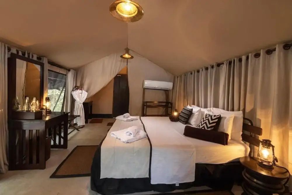 Komfortables Zeltzimmer mit Doppelbett und eleganten Details, sanft beleuchtet