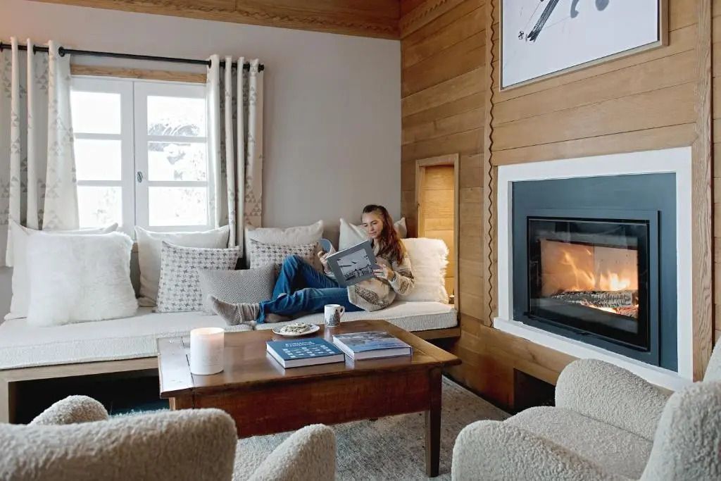 Gemütliche Sitzecke mit Kamin, Büchern und einladender Atmosphäre im Hotelzimmer.