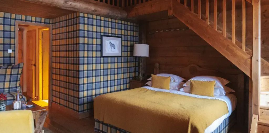 Rustikales Schlafzimmer mit Holzwänden und gelben Akzenten im Duplex Familienzimmer