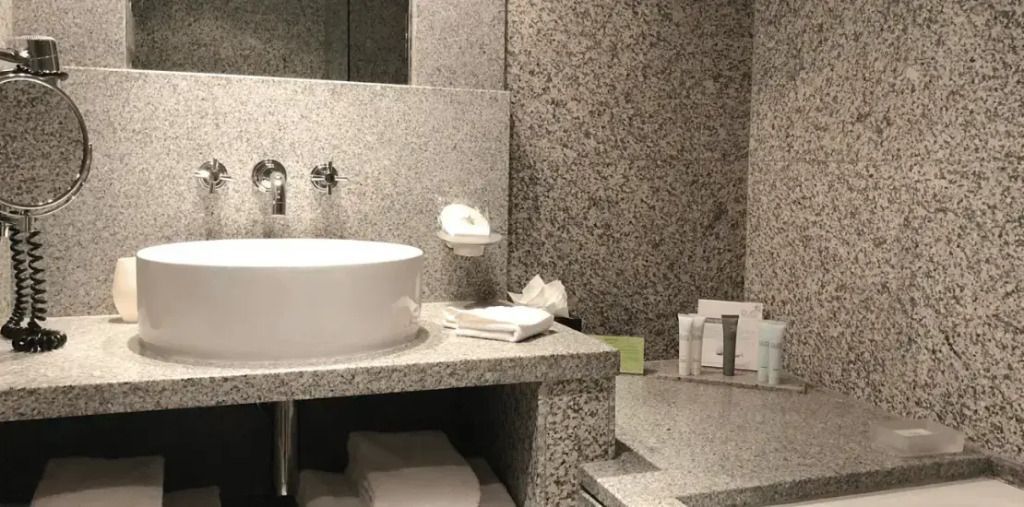 Modernes Badezimmer mit Granitfliesen und runder Waschschüssel