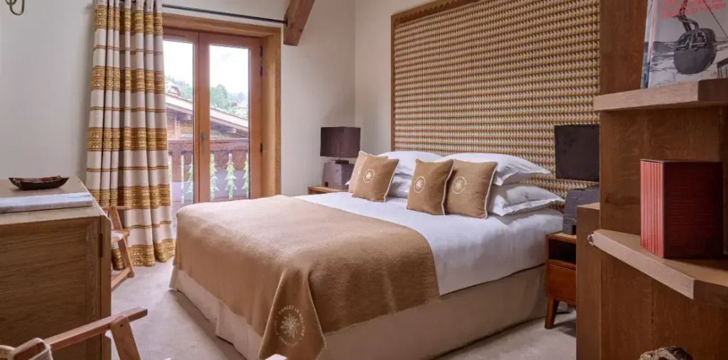 Gemütliches Schlafzimmer mit Holzbalken und eleganten Kissen im Les Fermes De Marie.