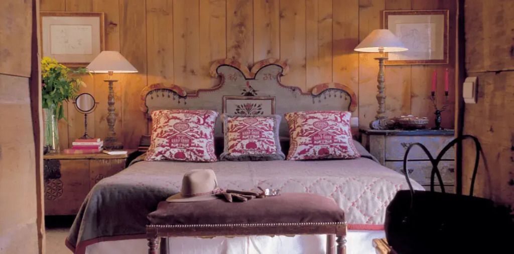 Rustikales Schlafzimmer mit Holzvertäfelung und rotem Dekor in einer Suite