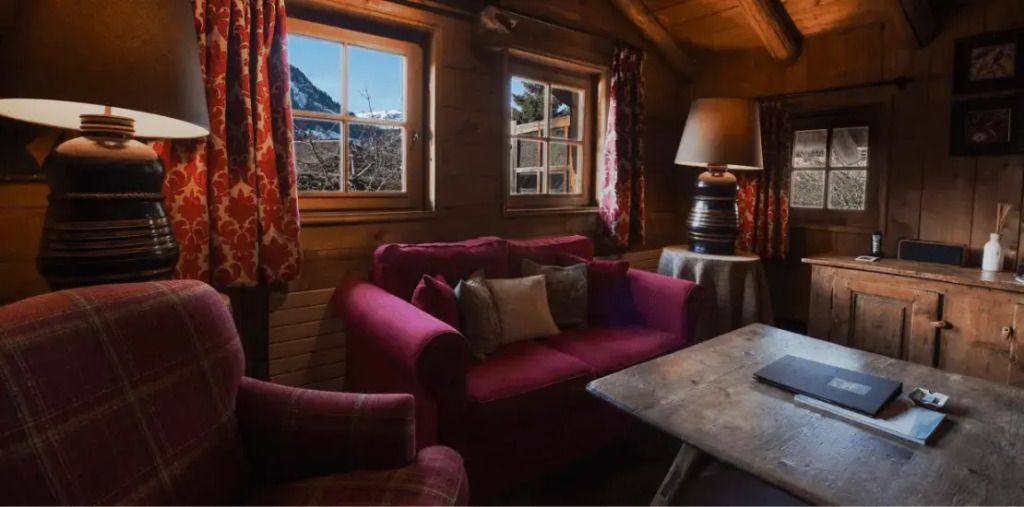 Sitzecke mit rotem Sofa und Blick auf die Berge