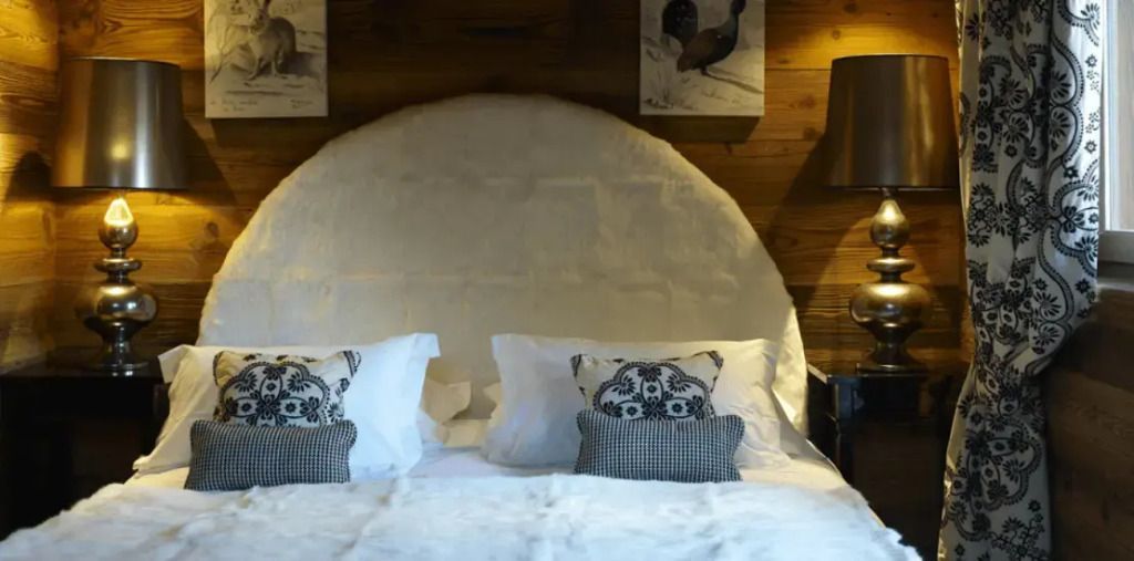 Doppelbett mit runden Kopfteil in der Mont Joly Suite aus Holz.