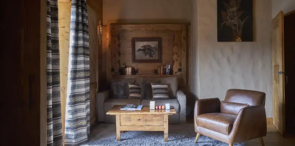 Rustikale Sitzecke mit Holzmöbeln und gemütlichem Sofa in der Suite