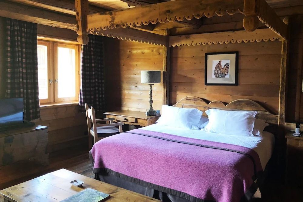Charmantes Zimmer mit Holzverkleidung und lila Decke im Hotel Les Fermes De Marie