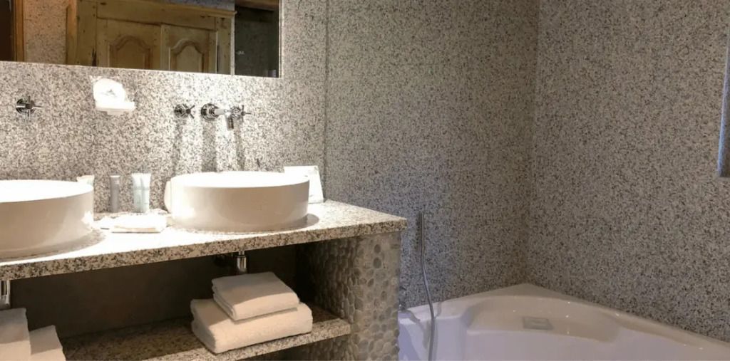 Modernes Badezimmer mit Granitoberflächen und integrierter Badewanne