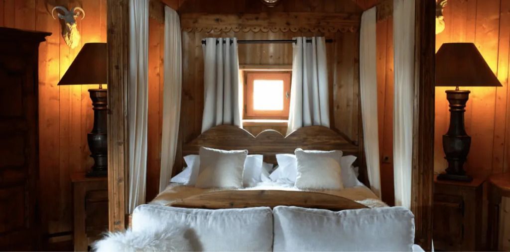Romantisches Schlafzimmer mit Holzakzenten und großen Kissen auf dem Doppelbett