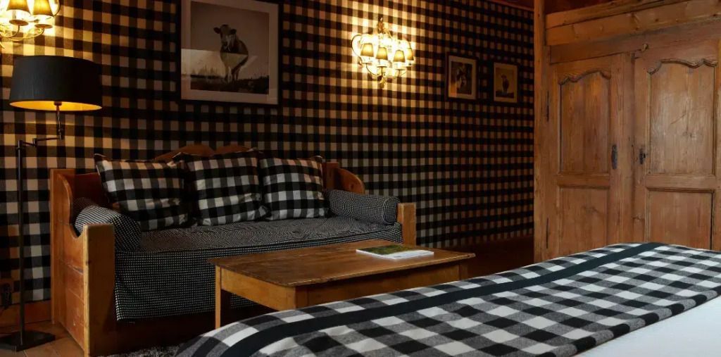 Wohnbereich mit karierten Stoffen und gemütlicher Couch in alpinem Design.
