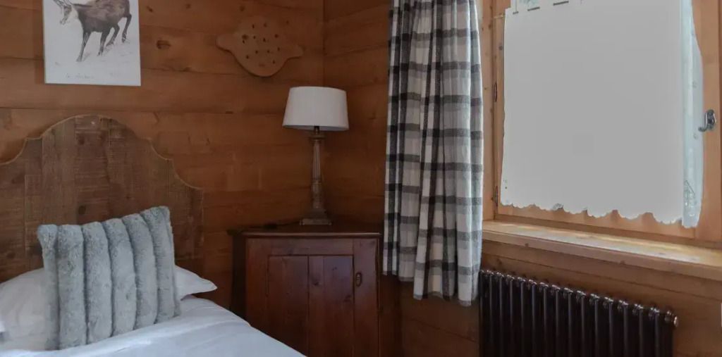 Sitzecke mit Holzmöbeln und Fenster in rustikaler Holzvertäfelung.