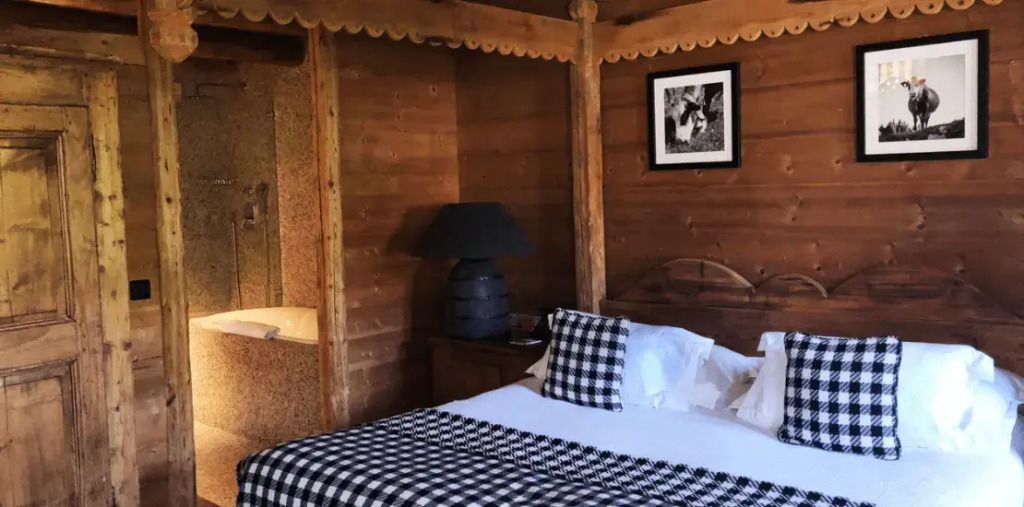 Gemütliches Holzinterieur mit einem Doppelbett und karierten Akzenten im Superior-Familienzimmer