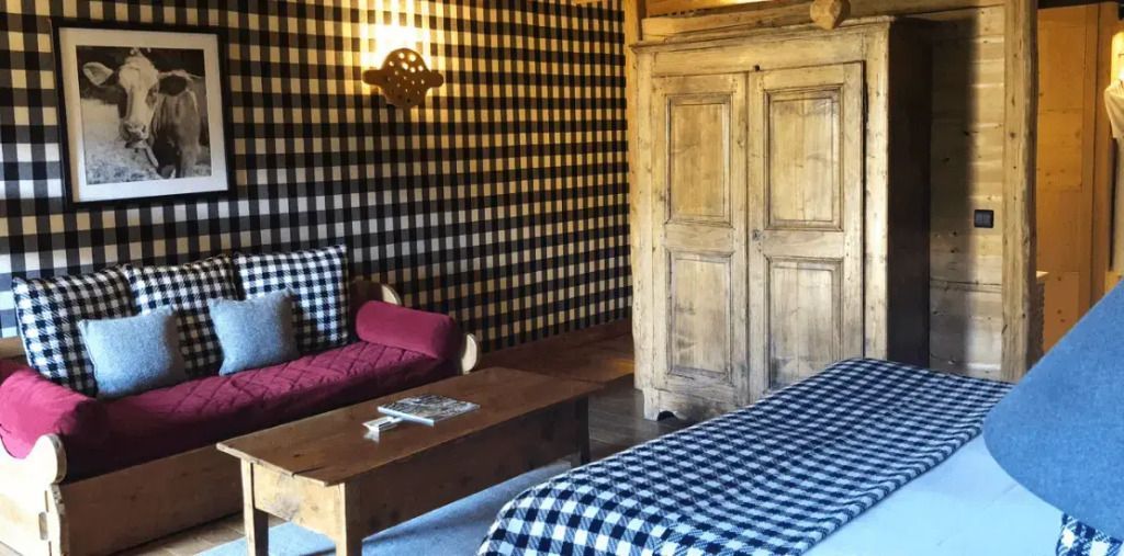 Zimmer mit karierten Wänden, Holzmöbeln und gemütlicher Sitzecke im Superior-Familienzimmer
