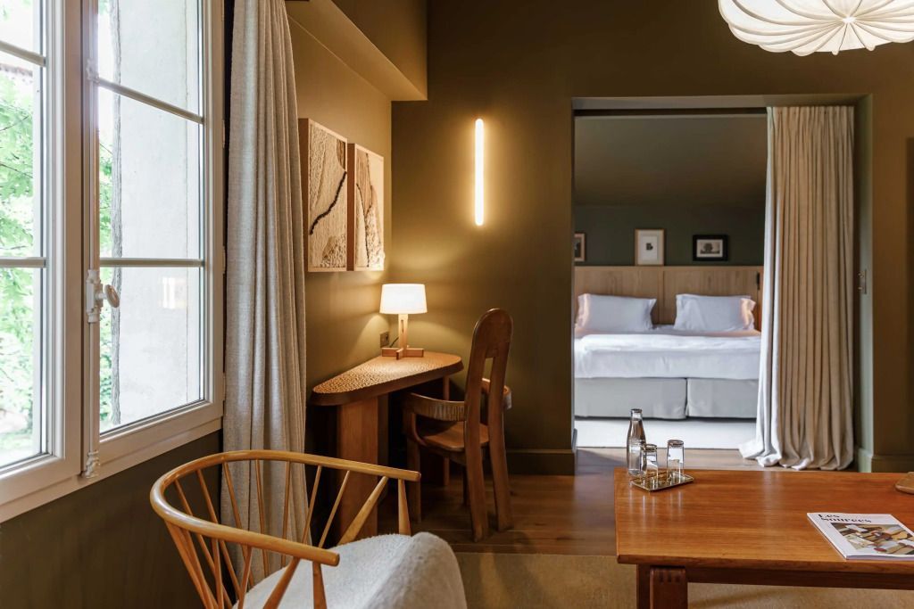 Schreibtischbereich in Suite, warm beleuchtet mit Kunstwerken und Sesseln