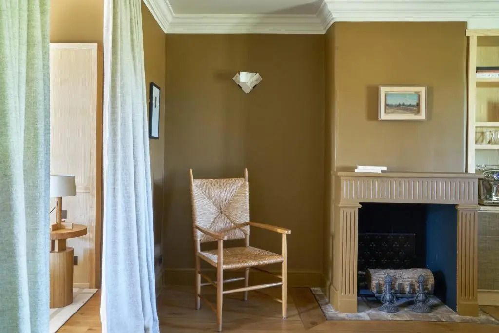 Sitzecke mit Kamin und Rattan-Stuhl in der Komfort Suite