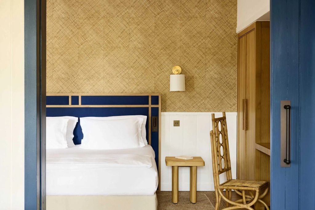 Schlafbereich mit elegantem Bett und Rattanmöbeln