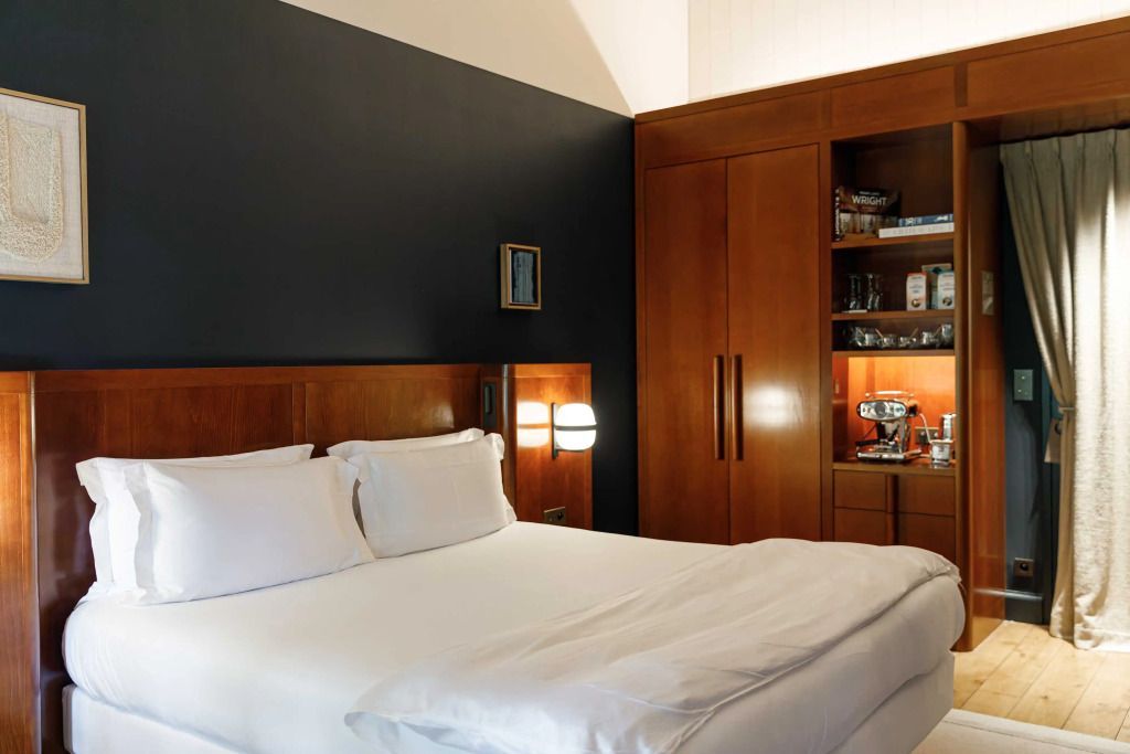 Doppelbett im Prestige Zimmer mit eleganten Holzdetails und einem offenen Regal