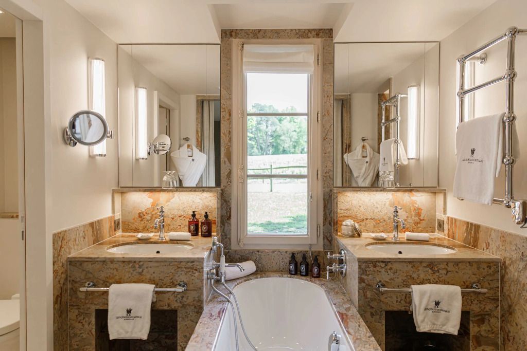 Luxuriöses Badezimmer mit einer Badewanne und großen Spiegeln im Prestige Zimmer