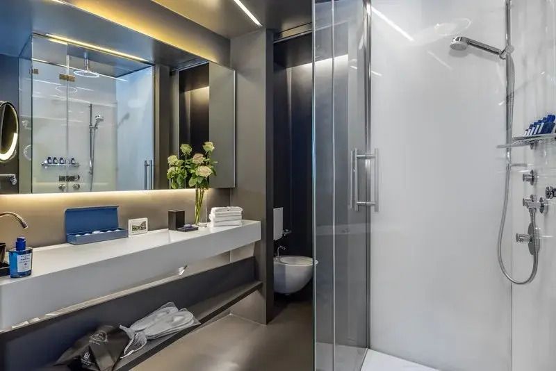 Modernes Badezimmer mit Glasdusche und eleganter Beleuchtung