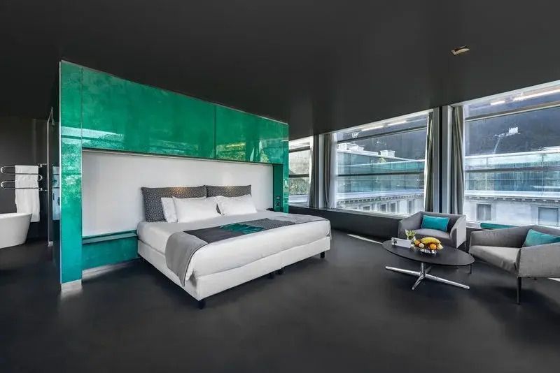 Modernes Schlafzimmer mit Doppelbett und großen Fenstern in Sky Mountain Suite
