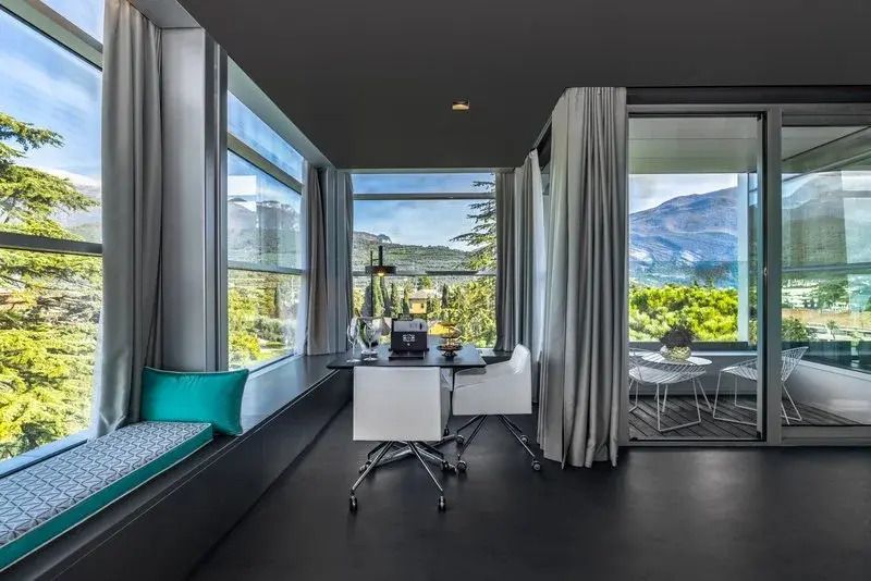 Panoramafenster mit Blick auf Berge und Terrasse in der Sky Mountain Suite