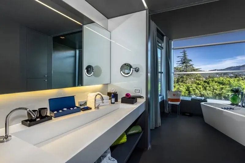Badezimmerbereich mit großem Spiegel und Annehmlichkeiten in der Suite