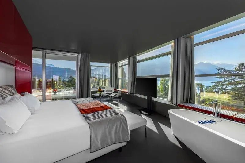 Helle Suite mit großem Bett und Seeblick an einem sonnigen Tag