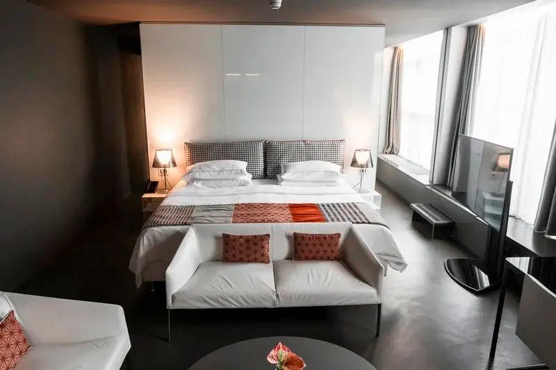 Luxuriöse Suite mit stilvollem Bett und seitlicher Fensterfront