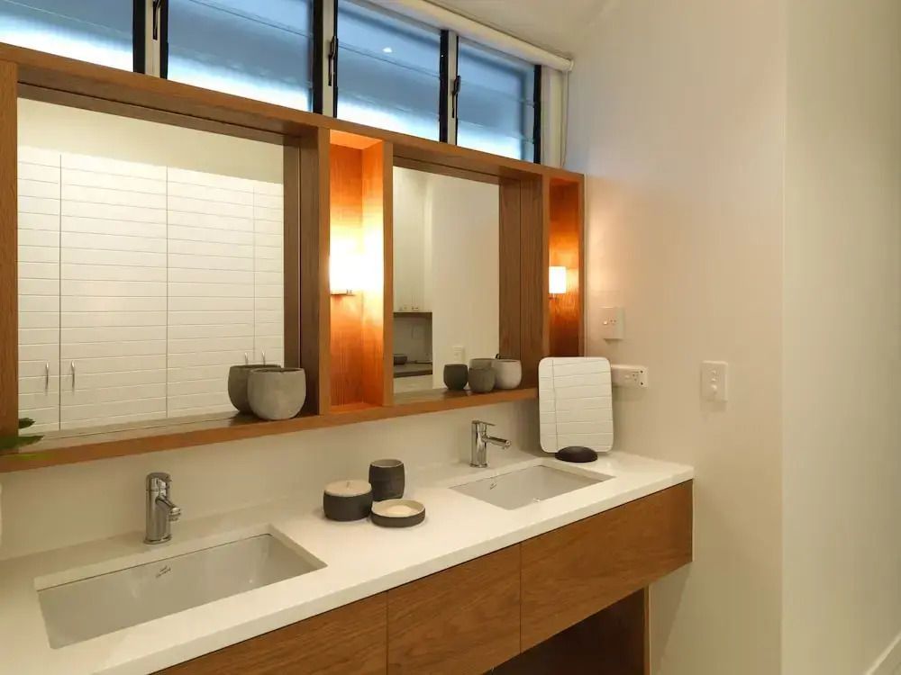 Modernes Badezimmer mit Doppelwaschbecken und Holzdetails im Lizard Island Resort.