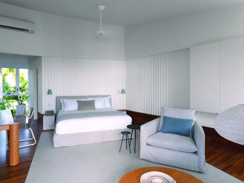 Luxuriöses Schlafzimmer mit Doppelbett und bequemen Sitzgelegenheiten.