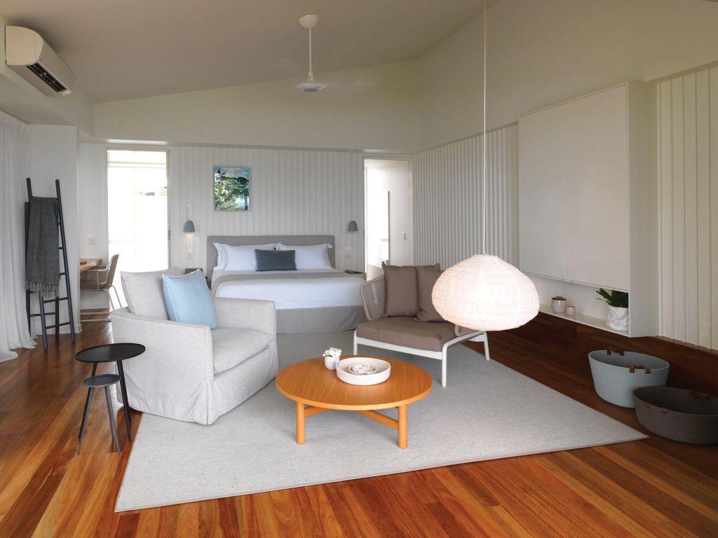 Geräumige Suite mit Doppelbett in neutralen Tönen und gemütlicher Sitzecke