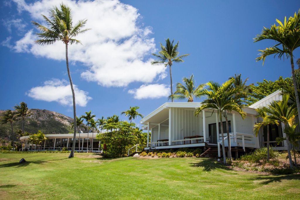 Außenansicht der modernen Villen des Lizard Island Resorts mit Palmen und blauem Himmel